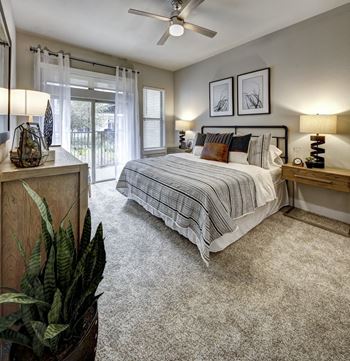 A bedroom with a bed, nightstands, and a ceiling fan.